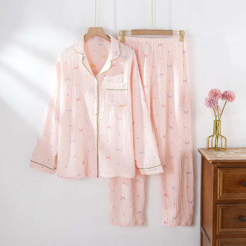 allvariants:: Pink pajama set with floral patterns hanging on a wooden hanger against a white wall.