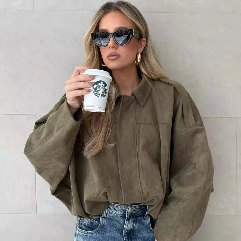 army green::Woman in a brown jacket holding a Starbucks cup against a light background