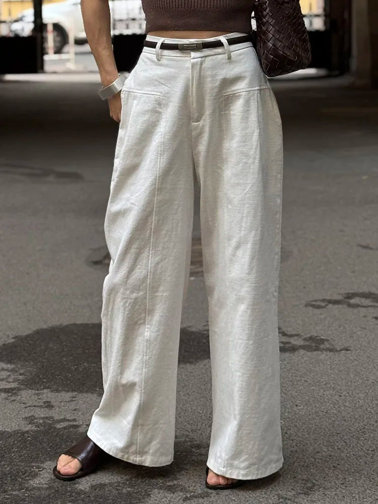 allvariants:: Person wearing light-colored wide-leg pants on a street.