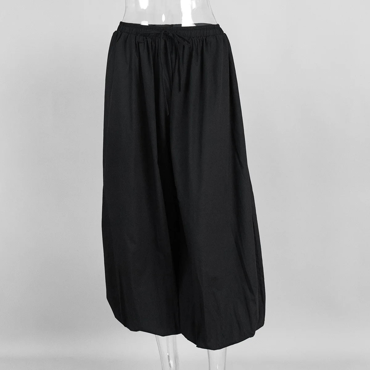 Black:: skirt on a mannequin against a gray background