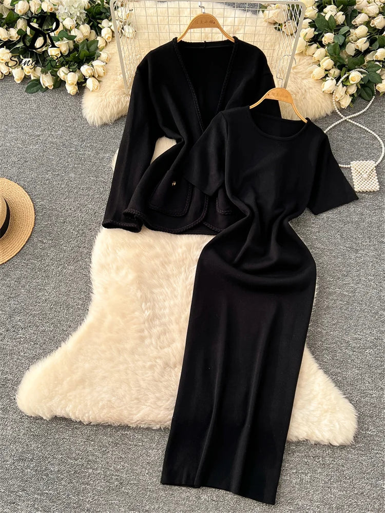 allvariants:: Black dress on a hanger with a white pillow and floral decorations in the background