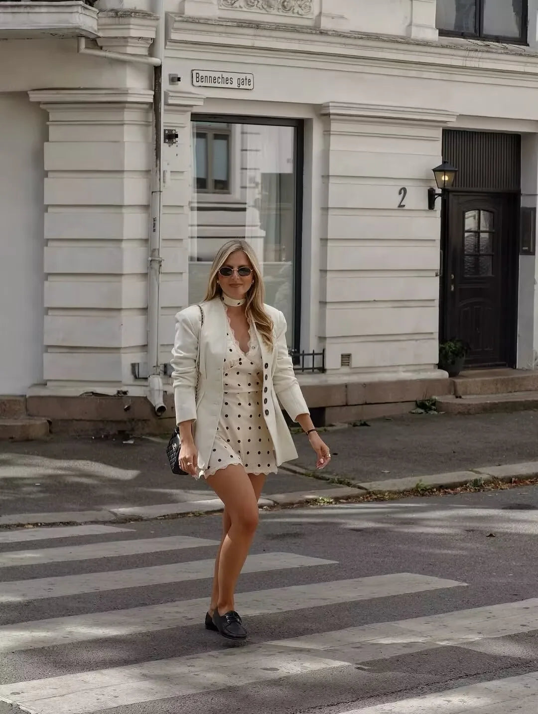 White::Woman walking on a zebra crossing in an urban setting